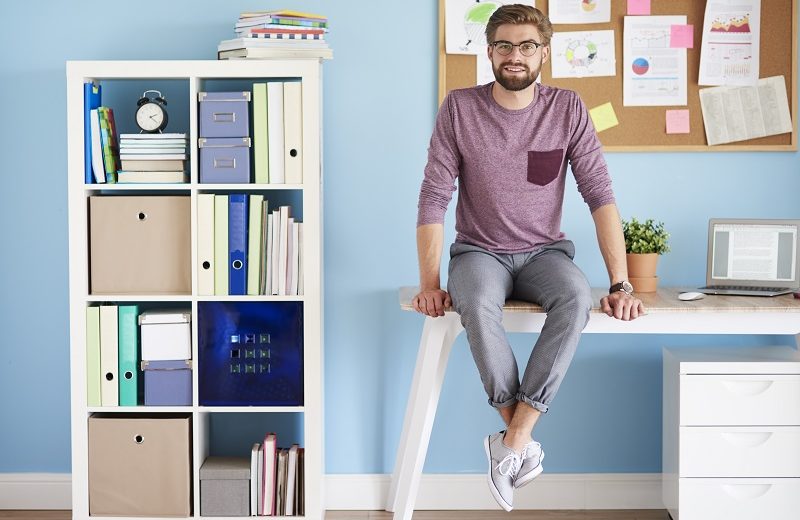 Man sitting on desk in the home office